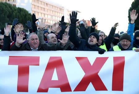 Taxi drivers shout slogans during a strike against the regulation of ride-hailing and car-sharing services such as Uber and Cabify, outside IFEMA fair pavilions in Madrid, Spain, January 23, 2019. REUTERS/Sergio Perez