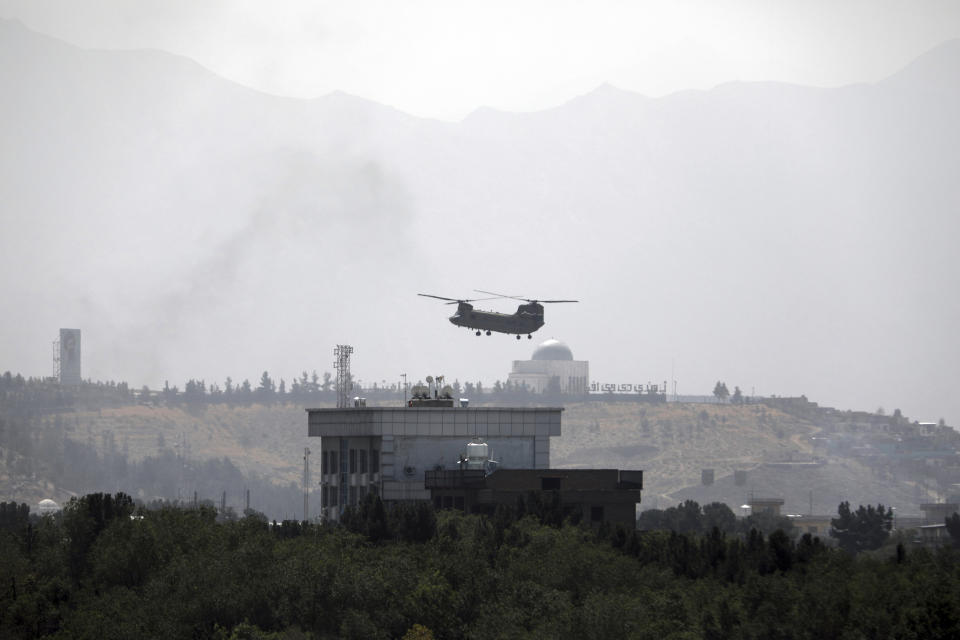 FILE - In this Sunday, Aug. 15, 2021 file photo, a U.S. Chinook helicopter flies over the U.S. embassy in Kabul, Afghanistan. Helicopters landed at the embassy as diplomatic vehicles left the compound amid the Taliban advance on the Afghan capital. (AP Photo/Rahmat Gul, File)