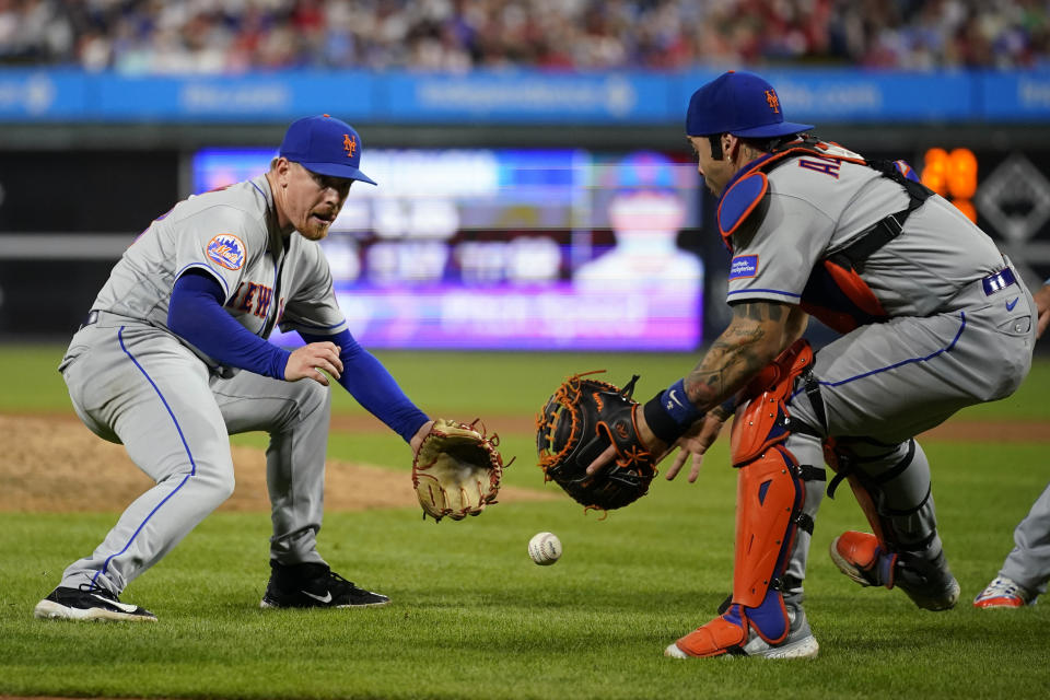 New York Mets pitcher Jeff Brigham, left, and catcher Francisco Alvarez chase a fielder's choice batted by Philadelphia Phillies' Cristian Pache during the sixth inning of a baseball game, Thursday, Sept. 21, 2023, in Philadelphia. (AP Photo/Matt Slocum)