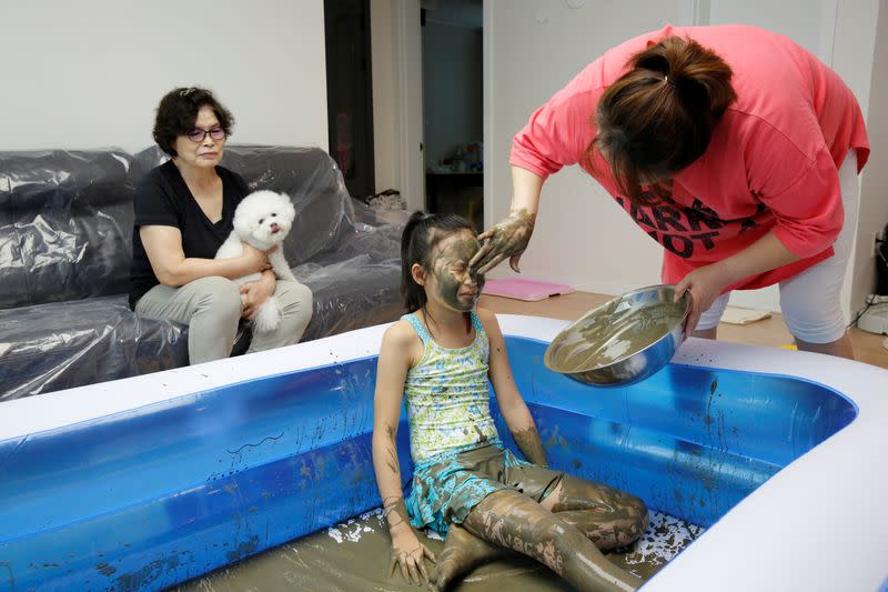 A girl with colored mud on her face is seen during the Online Boryeong Mud Festival at her home during a live streaming event, in Gwangju