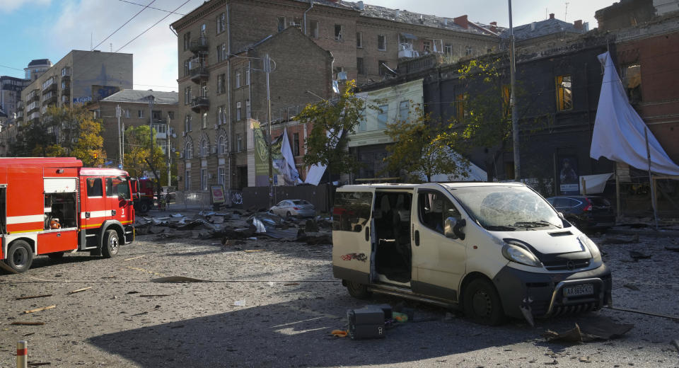 Damaged cars and buildings seen at the scene of Russian shelling in Kyiv, Ukraine, Monday, Oct. 10, 2022. Multiple explosions rocked Kyiv early Monday following months of relative calm in the Ukrainian capital. Kyiv Mayor Vitali Klitschko reported explosions in the city's Shevchenko district, a large area in the center of Kyiv that includes the historic old town as well as several government offices. (AP Photo/Efrem Lukatsky)