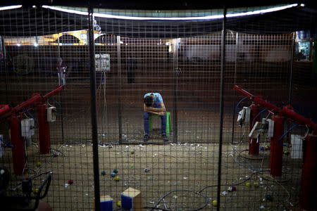 A man takes a rest while waiting for customers at luna park at recently opened international fair in Damascus, Syria, September 12, 2018. REUTERS/Marko Djurica/Files