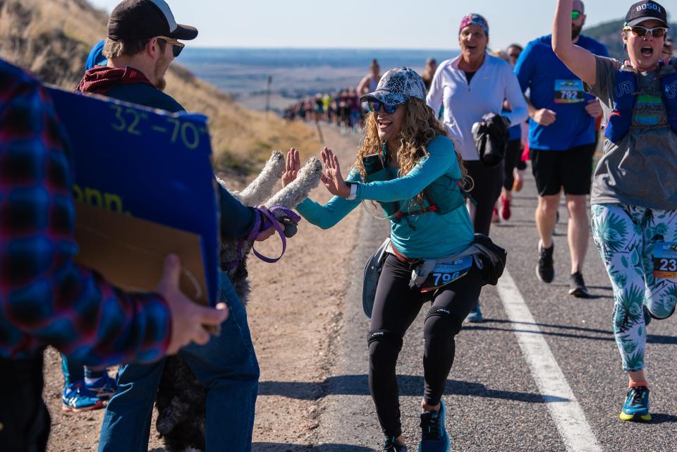 Runner Yesenia Goodwin gives Ash, an Aussiedoodle, a high-five as she makes her way up Monster Mountain during the 50th Horsetooth Half Marathon on April 16, 2023, in Fort Collins.