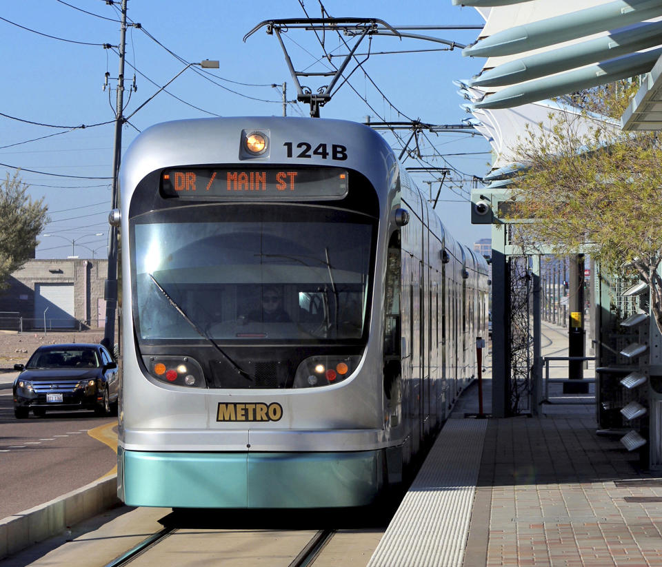 FILE - In this Jan. 16, 2016 file photo, a Metro Light Rail train stops for passengers in Phoenix. Campaigning over the future of mass rail transit in Phoenix rolled into the final stretch Monday, Aug. 26, 2019 as more voters returned early ballots weighing whether to halt all expansion of the light rail system. Early mail-in ballots have already pushed overall turnout for Tuesday's special election higher than one held four years ago at the height of the Phoenix summer, when many people leave to escape triple-digit temperatures. (AP Photo/Paul Davenport, File)