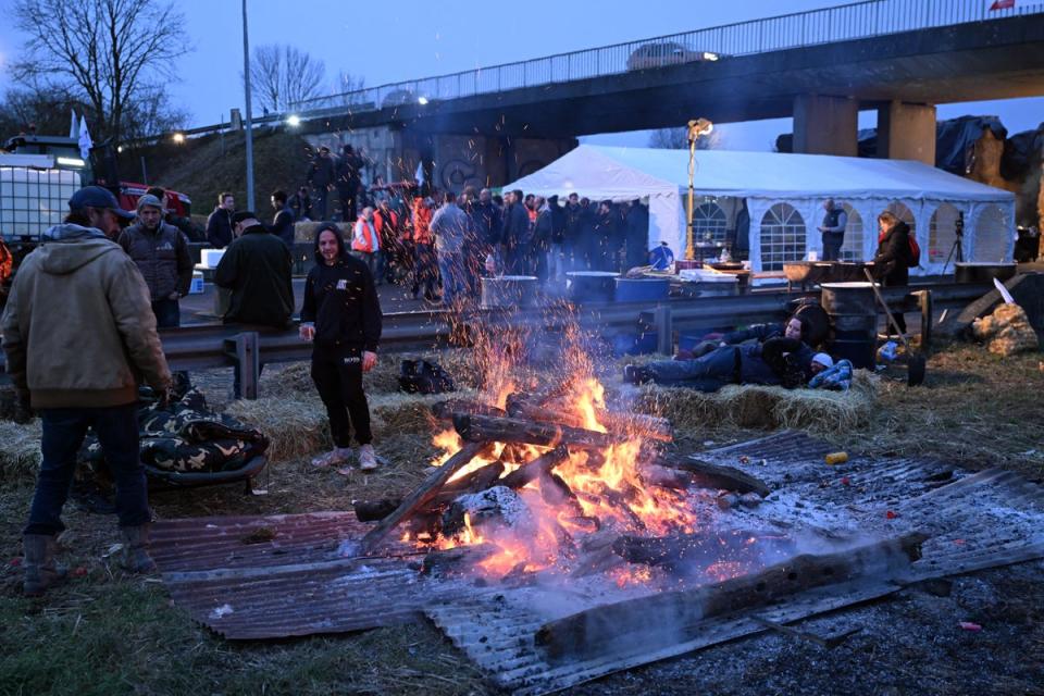 Farmers stay warm at their blockade on the A4 highway near Jossigny (AFP via Getty Images)