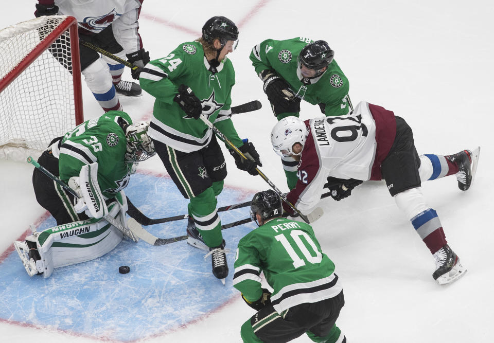 Dallas Stars goaltender Anton Khudobin (35) makes the save on Colorado Avalanche left wing Gabriel Landeskog (92) as Stars left wing Roope Hintz (24), right wing Corey Perry (10) and defenseman John Klingberg (3) defend during the second period of Game 3 of an NHL hockey second-round playoff series, Wednesday, Aug. 26, 2020, in Edmonton, Alberta. (Jason Franson/The Canadian Press via AP)