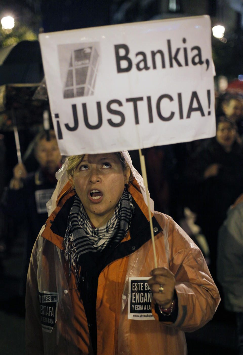 A woman holds a banner that reads: "Bankia, Justice!" as she shouts slogans against the banks during a march against evictions, in Madrid, Friday, Nov. 9, 2012. Officials say a woman fell to her death as bailiffs approached to evict her for non-payment of the mortgage from her fourth-floor apartment in a suburb of the northern Spanish city of Bilbao. Amaia Egana, 53-year-old, who worked at a local bus depot, was married to a former town councilor and had a 21-year-old daughter, launched herself off her balcony Friday, the regional Interior Ministry said. (AP Photo/Andres Kudacki)