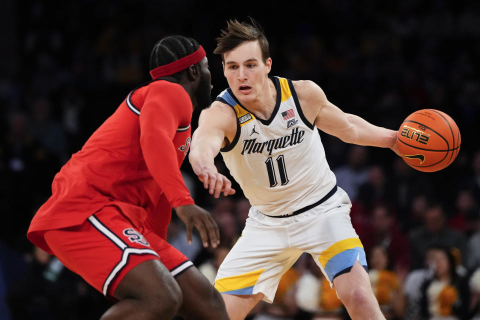 Marquette's Tyler Kolek (11) drives past St. John's Dylan Addae-Wusu during the first half of an NCAA college basketball game in the quarterfinals of the Big East Conference Tournament Thursday, March 9, 2023, in New York. Marquette won 72-70. (AP Photo/Frank Franklin II)