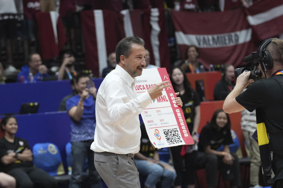 Latvia coach Luca Banchi, celebrates after his team's victory over Brazil during their Basketball World Cup second round match at the Indonesia Arena stadium in Jakarta, Indonesia, Sunday, Sept. 3, 2023. (AP Photo/Tatan Syuflana)