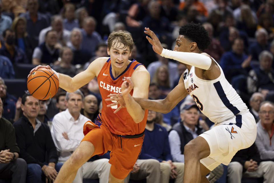 Clemson's Hunter Tyson (5) drives with the ball past Virginia's Ryan Dunn (13) during the first half of an NCAA college basketball game in Charlottesville, Va., Tuesday, Feb. 28, 2023. (AP Photo/Mike Kropf)