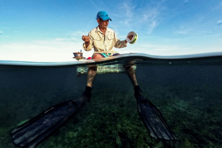 Un pescador cubano se prepara para pescar en una balsa improvisada en la bahía de La Habana el 16 de julio de 2024 (YAMIL LAGE)