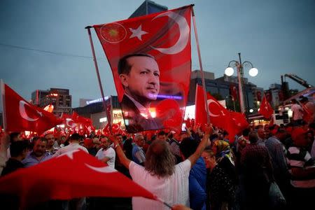 A supporter holds a flag depicting Turkish President Tayyip Erdogan during a pro-government demonstration in Ankara, Turkey, July 20, 2016. REUTERS/Baz Ratner