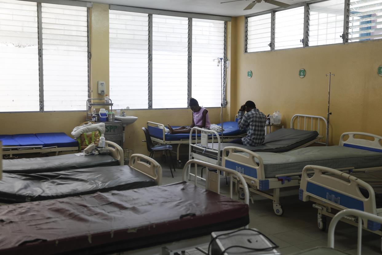 FILE - People sit in a hospital room that is empty because it lacks electricity at the La Paix Hospital, amid severe fuel shortages in Port-au-Prince, Haiti, Oct. 26, 2021. The U.S. government is urging U.S. citizens to leave Haiti given the country’s deepening insecurity and a severe lack of fuel that has affected hospitals, schools and banks. Gas stations remained closed on Thursday, Nov. 11, 2021, a day after the State Department issued its warning. (AP Photo/Odelyn Joseph, File)