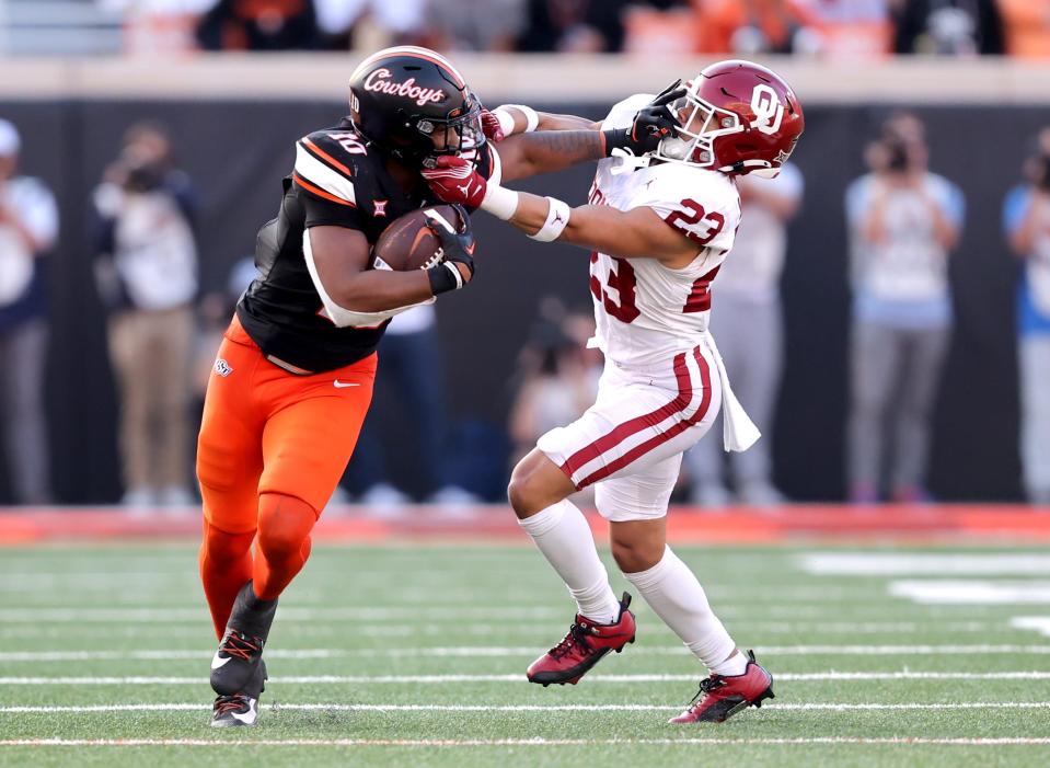 Oklahoma State's Rashod Owens (10) stiff arms Oklahoma's Jasiah Wagoner (23) during a Bedlam college football game between the Oklahoma State University Cowboys (OSU) and the University of Oklahoma Sooners (OU) at Boone Pickens Stadium in Stillwater, Okla., Saturday, Nov. 4, 2023.