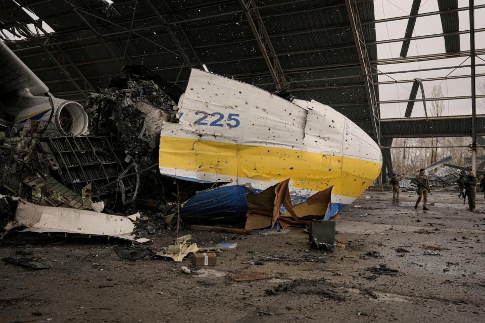 Ukrainian servicemen walk by an Antonov An-225 Mriya aircraft.