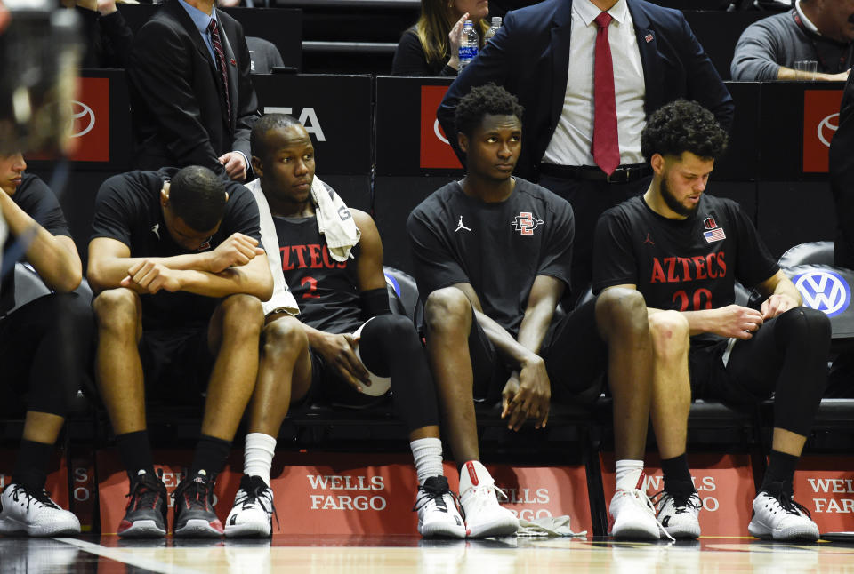 San Diego State players sit on the bench during the second half of an NCAA college basketball game against UNLV, Saturday, Feb. 22, 2020, in San Diego. UNLV won 66-63. (AP Photo/Denis Poroy)