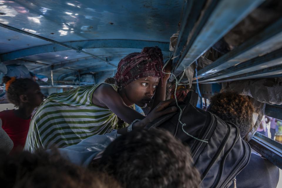 Tigray refugees who fled the conflict in the Ethiopia's Tigray ride a bus going to the Village 8 temporary shelter, near the Sudan-Ethiopia border, in Hamdayet, eastern Sudan, Tuesday, Dec. 1, 2020. (AP Photo/Nariman El-Mofty)