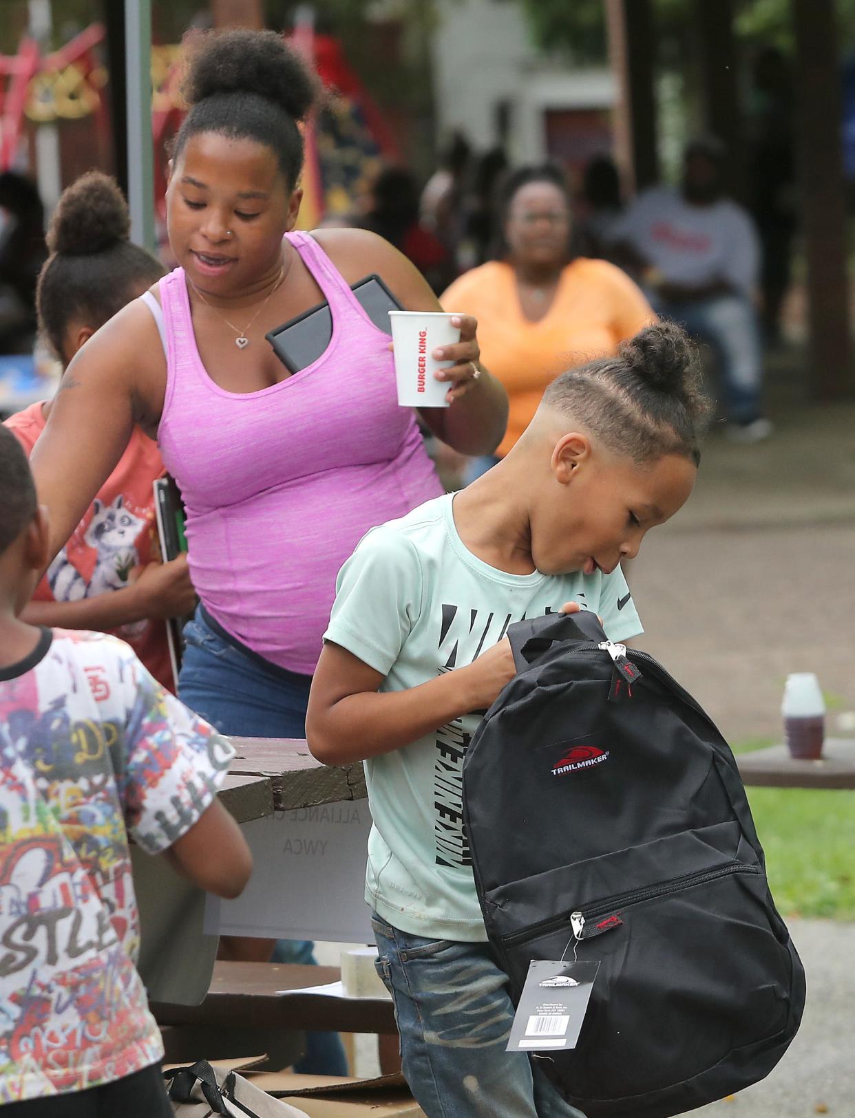 Liam Eremich, 7, right, gets excited checking out his new backpack as his mother Abigail Pancoast signs up for school supplies Saturday, Aug. 12, 2023, at the annual Back to School and Community Day at Thompson Snodgrass Park.