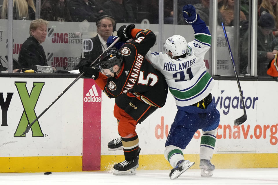 Vancouver Canucks left wing Nils Hoglander, right, breaks his stick as he collides with Anaheim Ducks defenseman Urho Vaakanainen during the second period of an NHL hockey game Sunday, March 3, 2024, in Anaheim, Calif. (AP Photo/Mark J. Terrill)