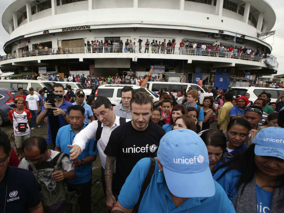 Former England soccer team captain David Beckham interacts with typhoon survivors during his visit to Typhoon Haiyan-hit Tacloban city, central Philippines, Thursday, Feb. 13, 2014. Beckham visited the storm-devastated Philippine city as part of UNICEF's relief efforts. (AP Photo/Bullit Marquez)