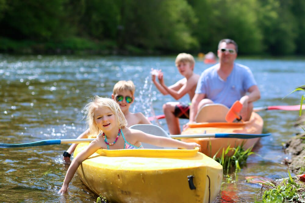 family kayaking on the river