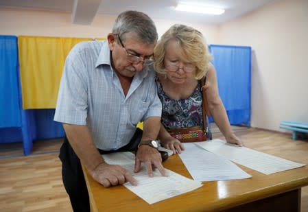 Voters look through ballots at a polling station during Ukraine's parliamentary election in Kiev