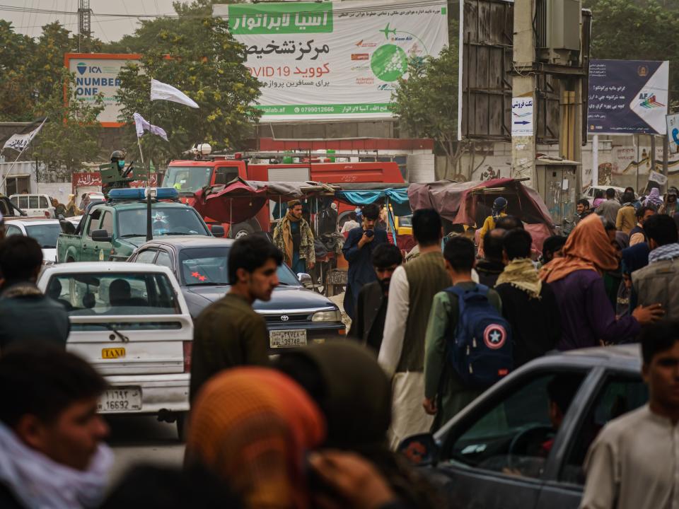 Afghans run away from Taliban fighters on airport road in Kabul, Afghanistan