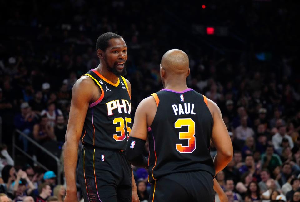 Suns guard Chris Paul (3) and forward Kevin Durant (35) talk after a foul against the Nuggets during a game at Footprint Center, April 6, 2023.