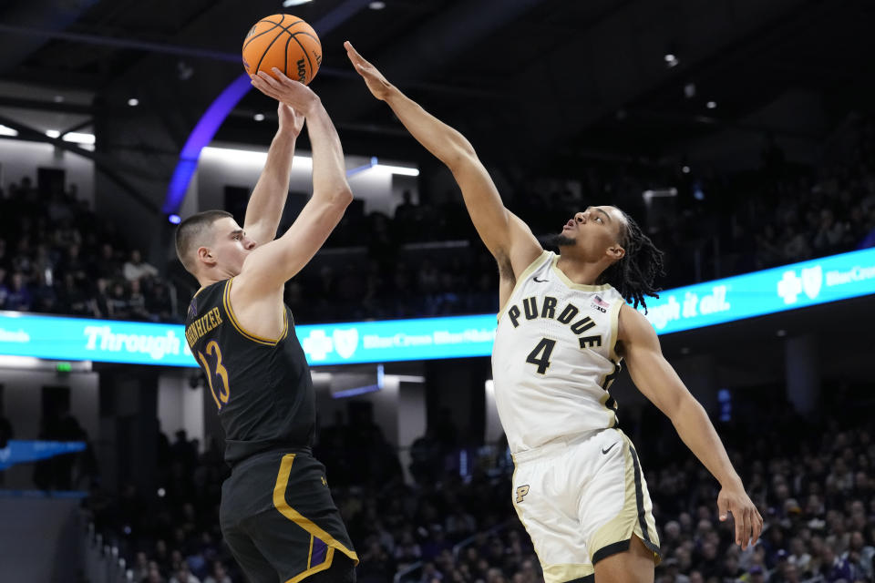 Northwestern guard Brooks Barnhizer, left, shoots against Purdue forward Trey Kaufman-Renn during the first half of an NCAA college basketball game in Evanston, Ill., Friday, Dec. 1, 2023. (AP Photo/Nam Y. Huh)