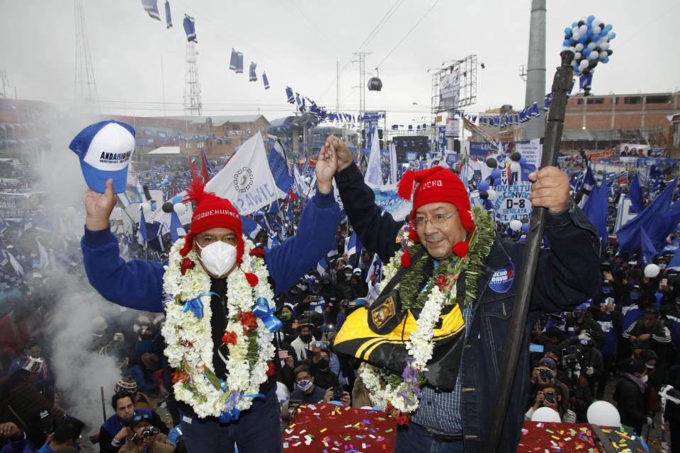 Luis Arce, right, Bolivian presidential candidate for the Movement Towards Socialism Party, MAS, right, and running mate David Choquehuanca hold hands during their closing campaign rally for the upcoming Oct. 18, presidential elections, in El Alto, Bolivia, Wednesday, Oct. 14, 2020. (AP Photo/Jorge Mamani)