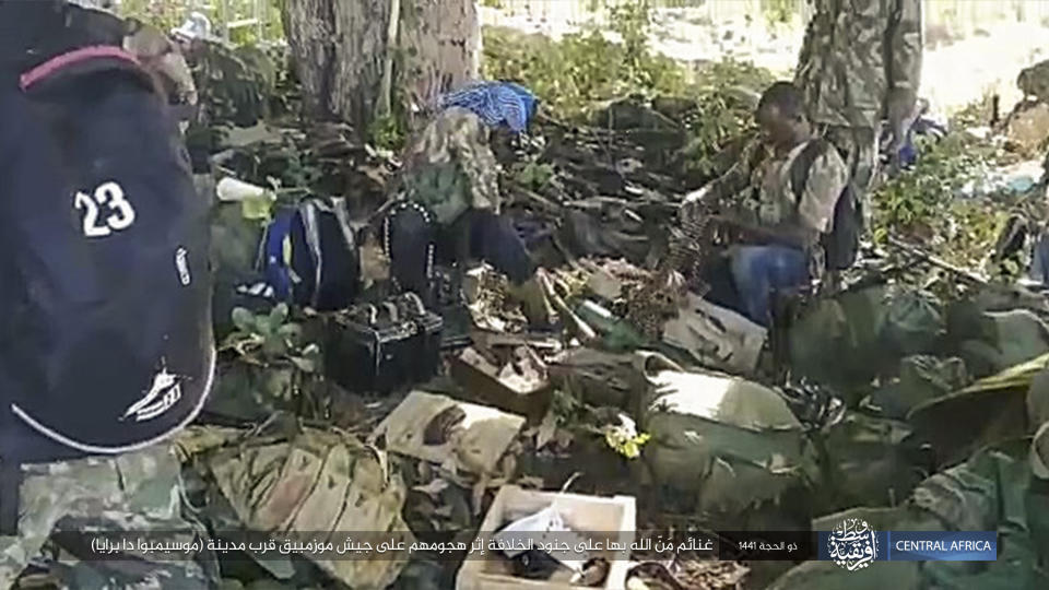 This image distributed online by the Islamic State Central Africa Province (ISCAP) and provided by SITE Intelligence Group shows ISCAP fighters and weapons following clashes with Mozambican government troops on Thursday, Aug. 6, 2020, near Mocimboa da Praia, in northern Mozambique. The stinging success of Mozambique's Islamic extremist rebels in seizing and holding the northern port city signals to the government, neighboring countries and the world that Africa has yet another insurgency hotspot. Writing in Arabic reads "Blessings of God are on the soldiers of the caliphate after their attack on the Mozambican army near the city of Mocimboa da Praia". (SITE Intelligence Group via AP)