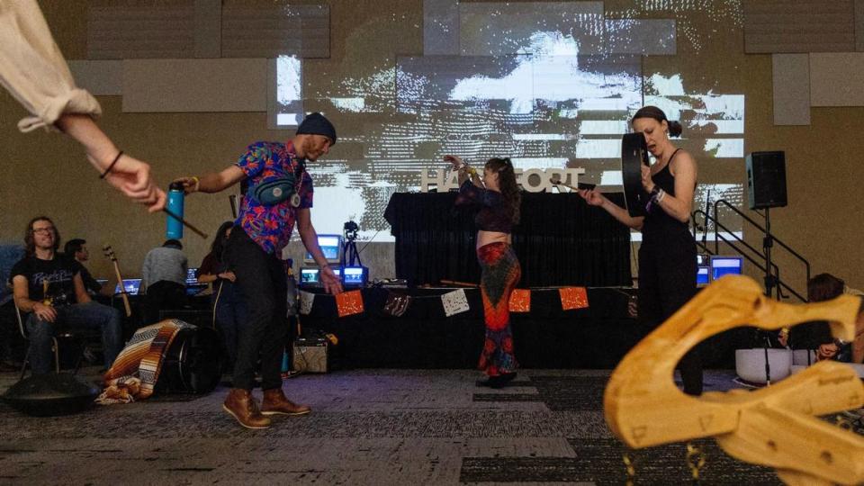 Participants dance and play musical instruments at a large video projection on the wall inside the interactive space at Hackfort on Thursday.