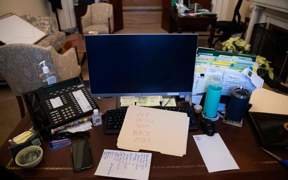 A supporter of President Donald Trump leaves a note in the office of US Speaker of the House Nancy Pelosi during a riot inside the US Capitol in Washington - SAUL LOEB /AFP