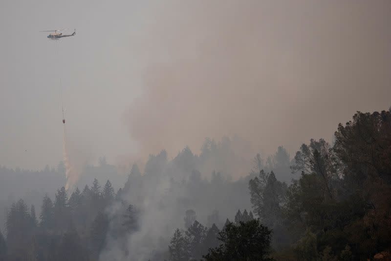 A helicopter drops water on the Glass Fire in Calistoga, California