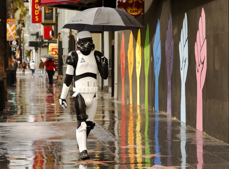 LOS ANGELES, CA - JANUARY 29: Stormtrooper needs to stay dry with an umbrella as he patrols the Hollywood Walk Of Fame in Hollywood as it continues to rain Friday as the third cold and wet storm system moves through the Southland.. Downtown on Friday, Jan. 29, 2021 in Los Angeles, CA. (Al Seib / Los Angeles Times).