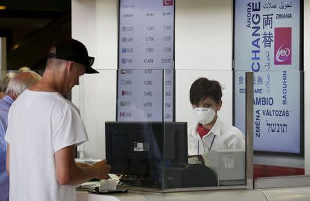A woman wears a mask as she works at Fiumicino international airport in Rome, Italy, July 13, 2015. REUTERS/Max Rossi