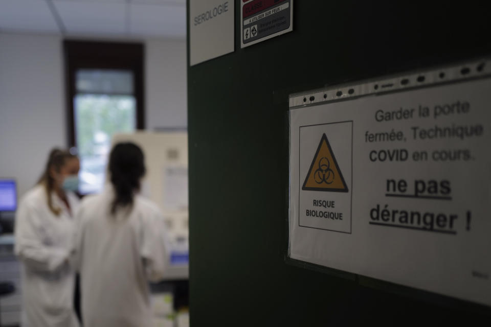 Health lab technicians process analysis of some nasal swab samples to test for COVID-19 at the Hospital of Argenteuil, north of Paris, Friday Sept. 25, 2020. France's health agency announced Thursday evening that the country has had 52 new deaths and has detected over 16,000 new cases of coronavirus in 24 hours. (AP Photo/Francois Mori)