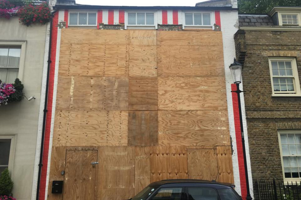 The striped house was boarded up and ready for demolition in July last year. (Barney Davis)