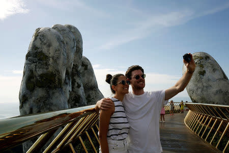 Tourists take photo on Gold Bridge on Ba Na hill near Danang city, Vietnam August 1, 2018. REUTERS/Kham