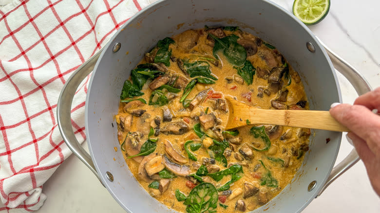 hand stirring dish in pot