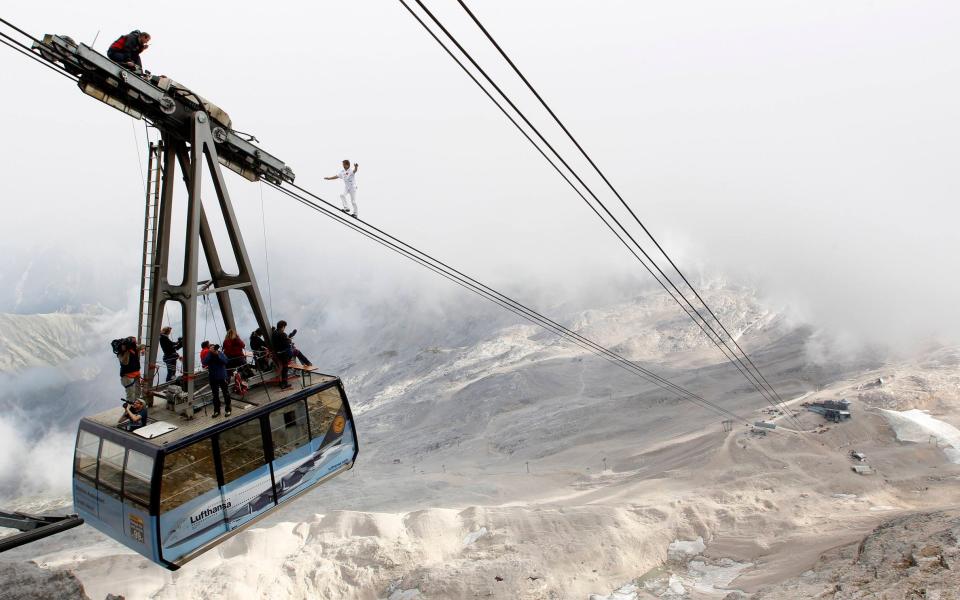 Nock balances on the ropeway of a cable car on Germany's highest mountain, Zugspitze, in 2011