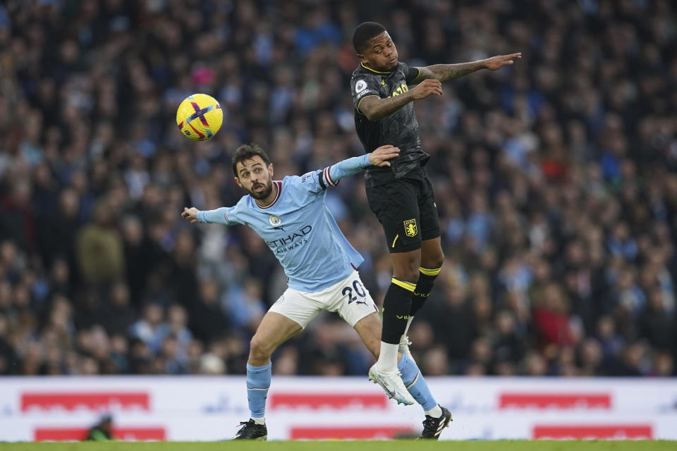 Manchester City's Bernardo Silva, left, challenges for the ball with Aston Villa's Leon Bailey during the English Premier League soccer match between Manchester City and Aston Villa at the Etihad Stadium in Manchester, England, Sunday, Feb. 12, 2023. (AP Photo/Dave Thompson)