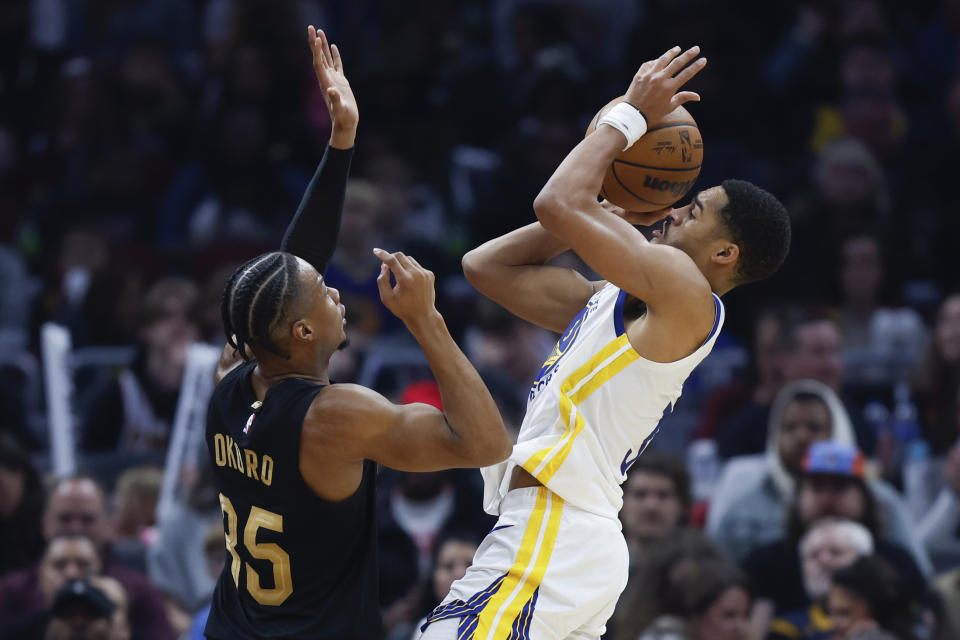 Golden State Warriors guard Jordan Poole shoots against Cleveland Cavaliers forward Isaac Okoro (35) during the first half of an NBA basketball game Friday, Jan. 20, 2023, in Cleveland. (AP Photo/Ron Schwane)