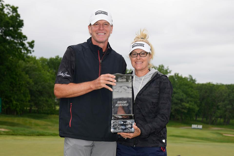 Steve Stricker holds the winner's trophy with his caddie and wife Nicki Stricker on the 18th green after winning the American Family Insurance Championship at University Ridge Golf Club on June 11, 2023, in Madison, Wisconsin.