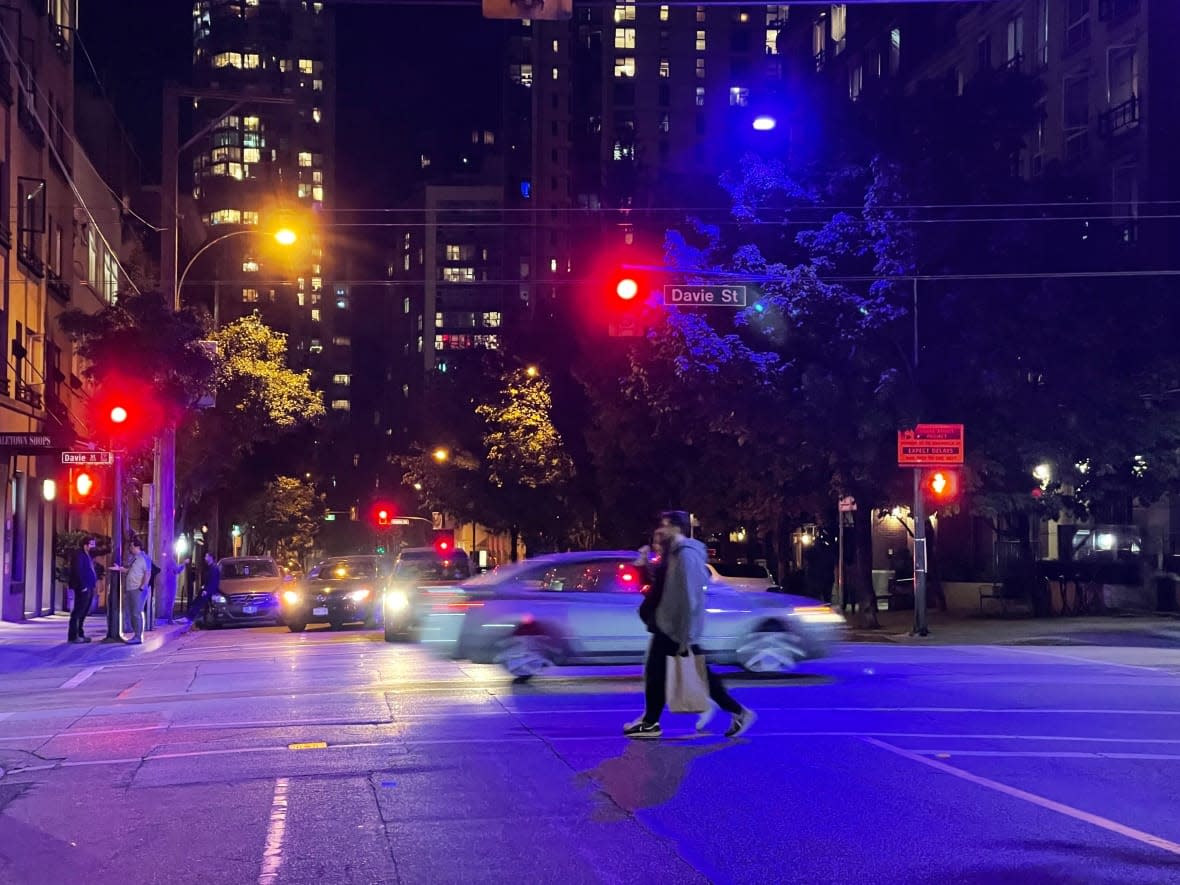 In Vancouver, more than 100 blue or purple street lights have been reported to the city — the result of a manufacturing defect involving a coating on the light. The downtown intersection of Davie and Richards Streets shows the contrast between the indigo lights, and the traditional orange street light. (Susana Da Silva/CBC - image credit)
