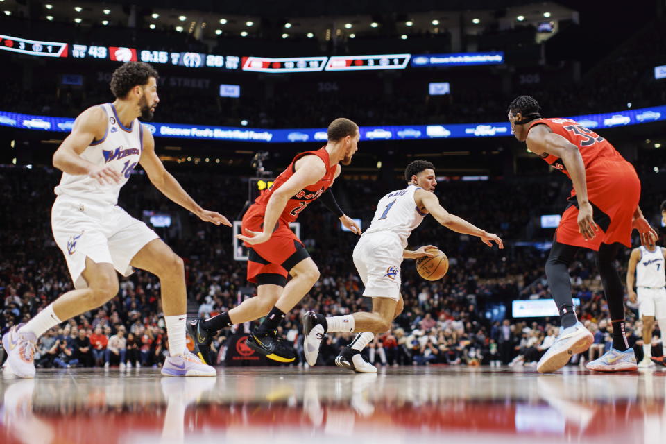 Washington Wizards guard Johnny Davis (1) dribbles as he is defended by Toronto Raptors guard Malachi Flynn (22) during the first half of an NBA basketball game in Toronto, Sunday, March 26, 2023. (Cole Burston/The Canadian Press via AP)