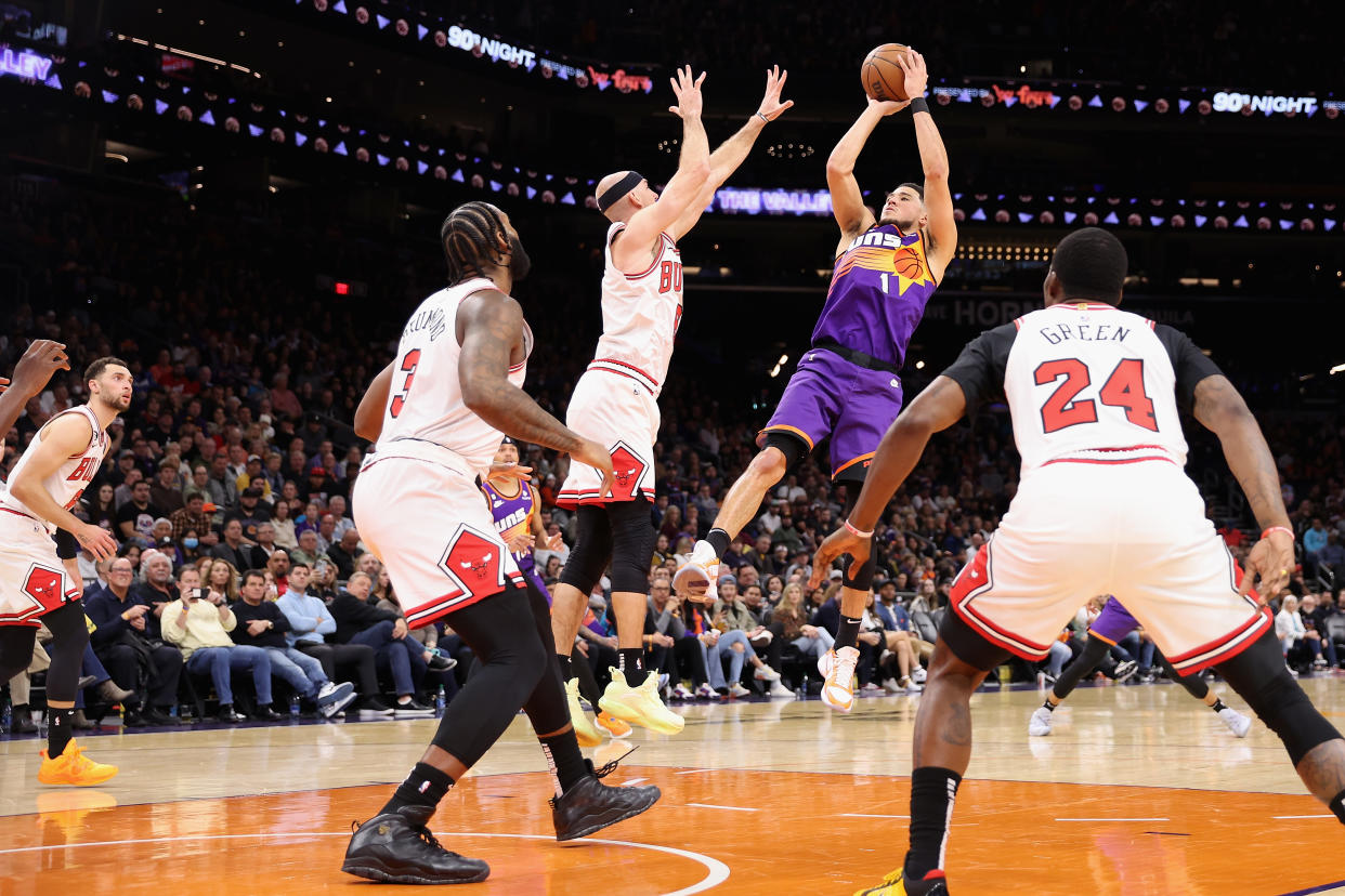PHOENIX, ARIZONA - NOVEMBER 30: Devin Booker #1 of the Phoenix Suns puts up a shot over Alex Caruso #6 of the Chicago Bulls during the first half of the NBA game at Footprint Center on November 30, 2022 in Phoenix, Arizona. The Suns defeated the Bulls 132-113. NOTE TO USER: User expressly acknowledges and agrees that, by downloading and or using this photograph, User is consenting to the terms and conditions of the Getty Images License Agreement. (Photo by Christian Petersen/Getty Images)
