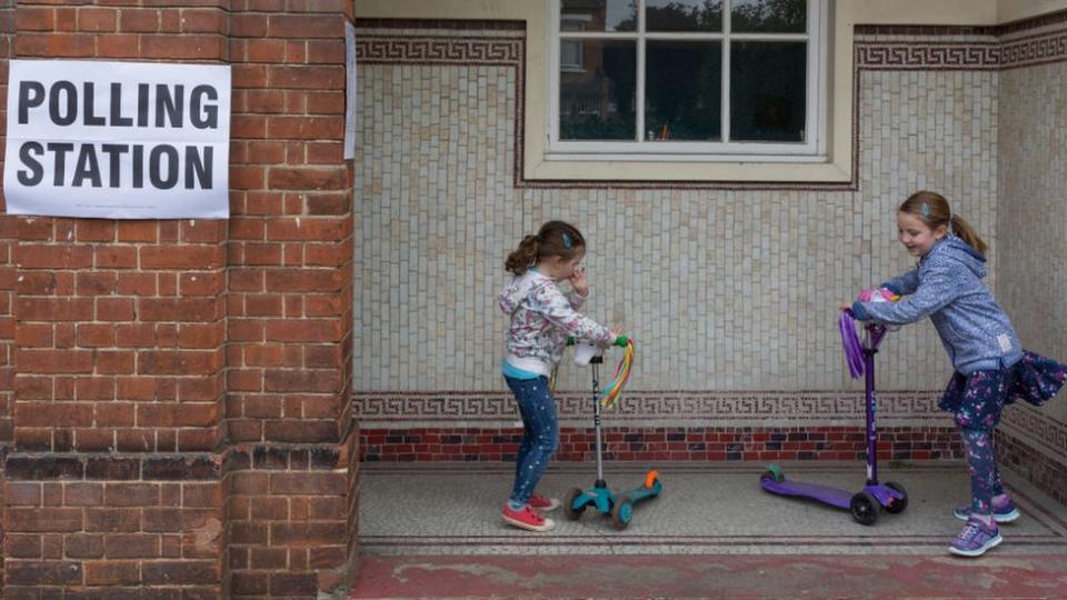 Children on scooters outside polling station