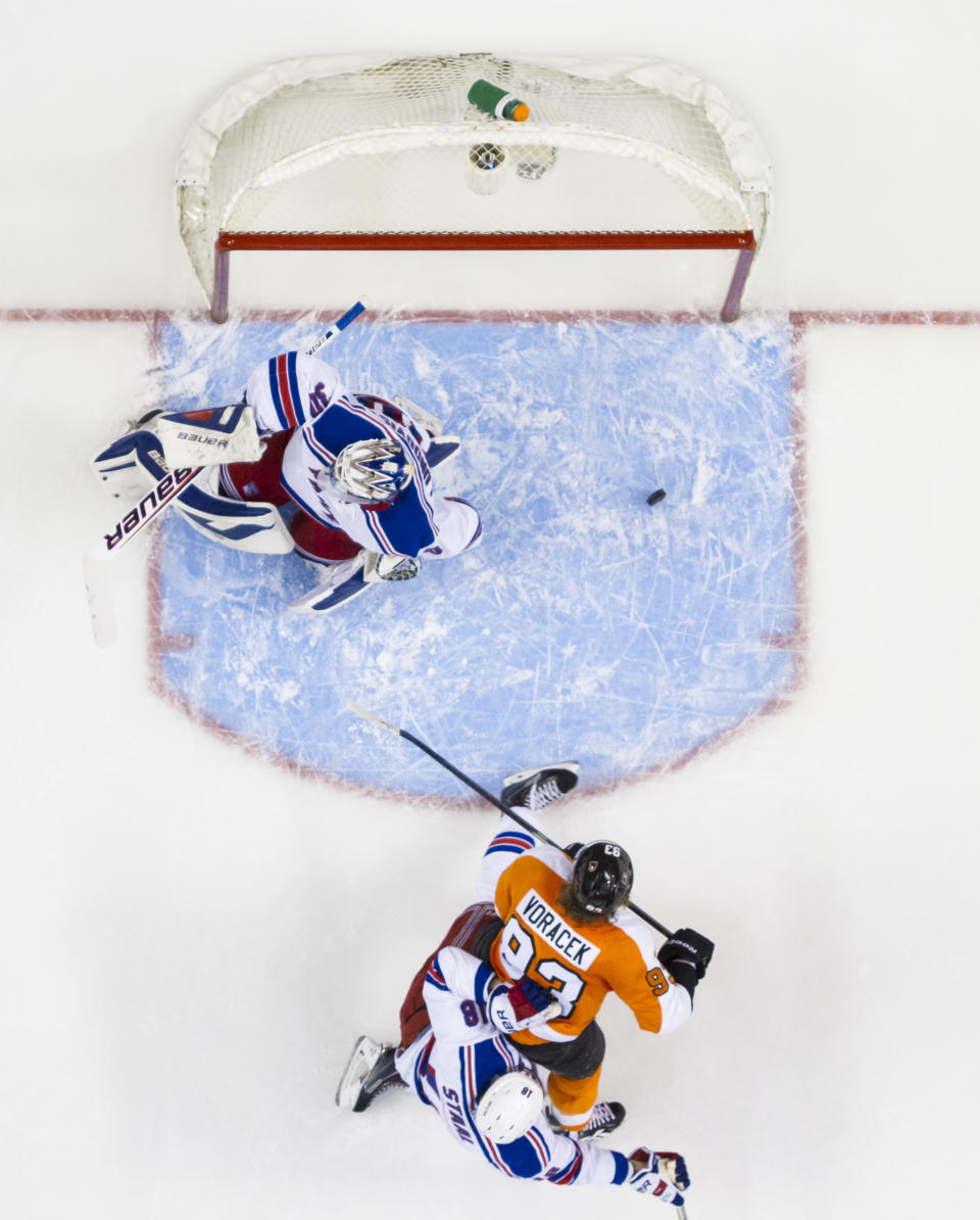 Philadelphia Flyers' Jakub Voracek, center, of the Czech Republic, watches his puck come back out of the net after a goal against New York Rangers' Henrik Lundqvist, top, of Sweden, with Marc Staal, bottom, defending during the second period in Game 4 of an NHL hockey first-round playoff series on Friday, April 25, 2014, in Philadelphia. (AP Photo/Chris Szagola)