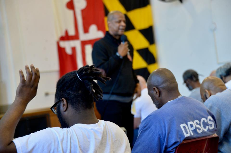 An inmate raises his hand Wednesday morning when Darryl Strawberry, professional baseball player turned ordained minister, asks if there's anyone who wants him to pray for them.